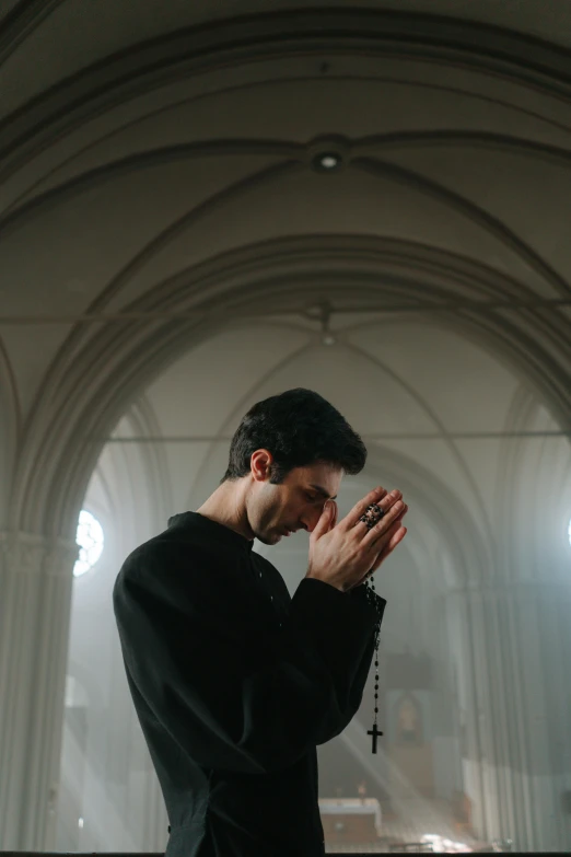 a person standing with their hands together praying