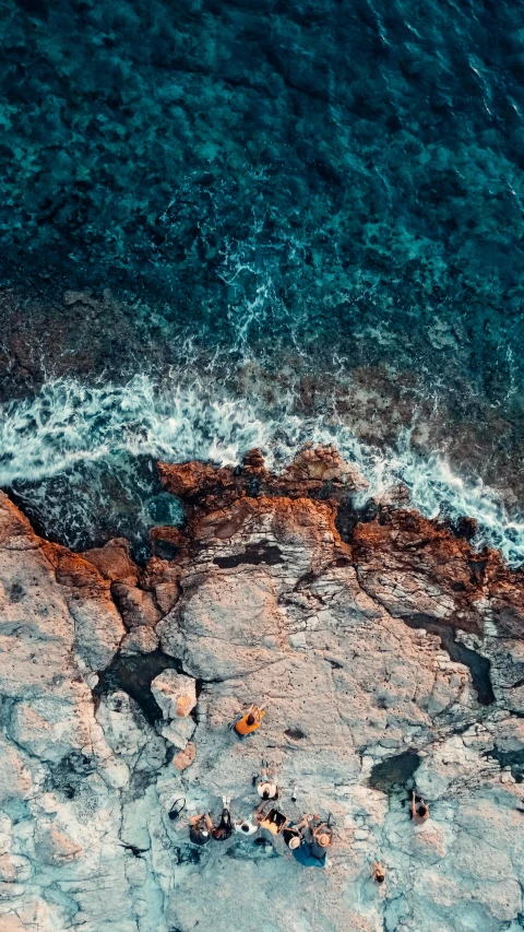 an aerial view of some blue water and rocks