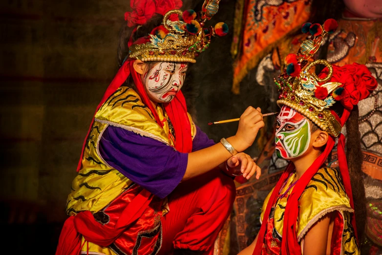 the girl is putting makeup on the girl in costume