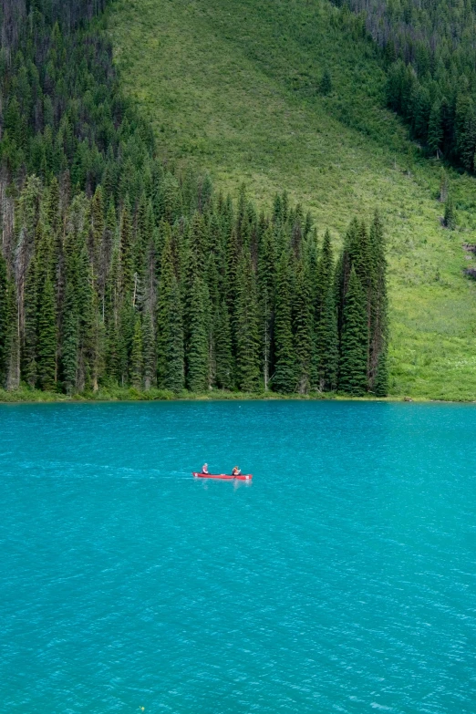 two people are canoe in a calm blue river