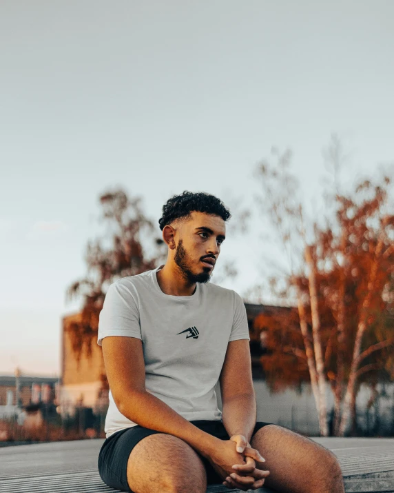 a man sitting on the ground staring at the sky