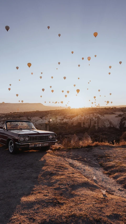 there are many balloons in the sky above cars