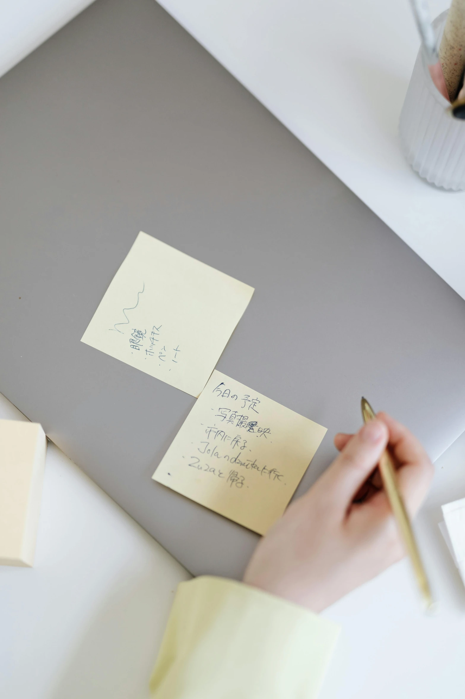 someone is taking notes from a note on a laptop