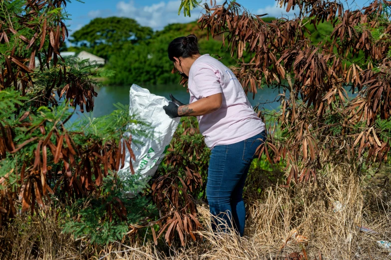 woman in blue jeans carrying a bag in her hands