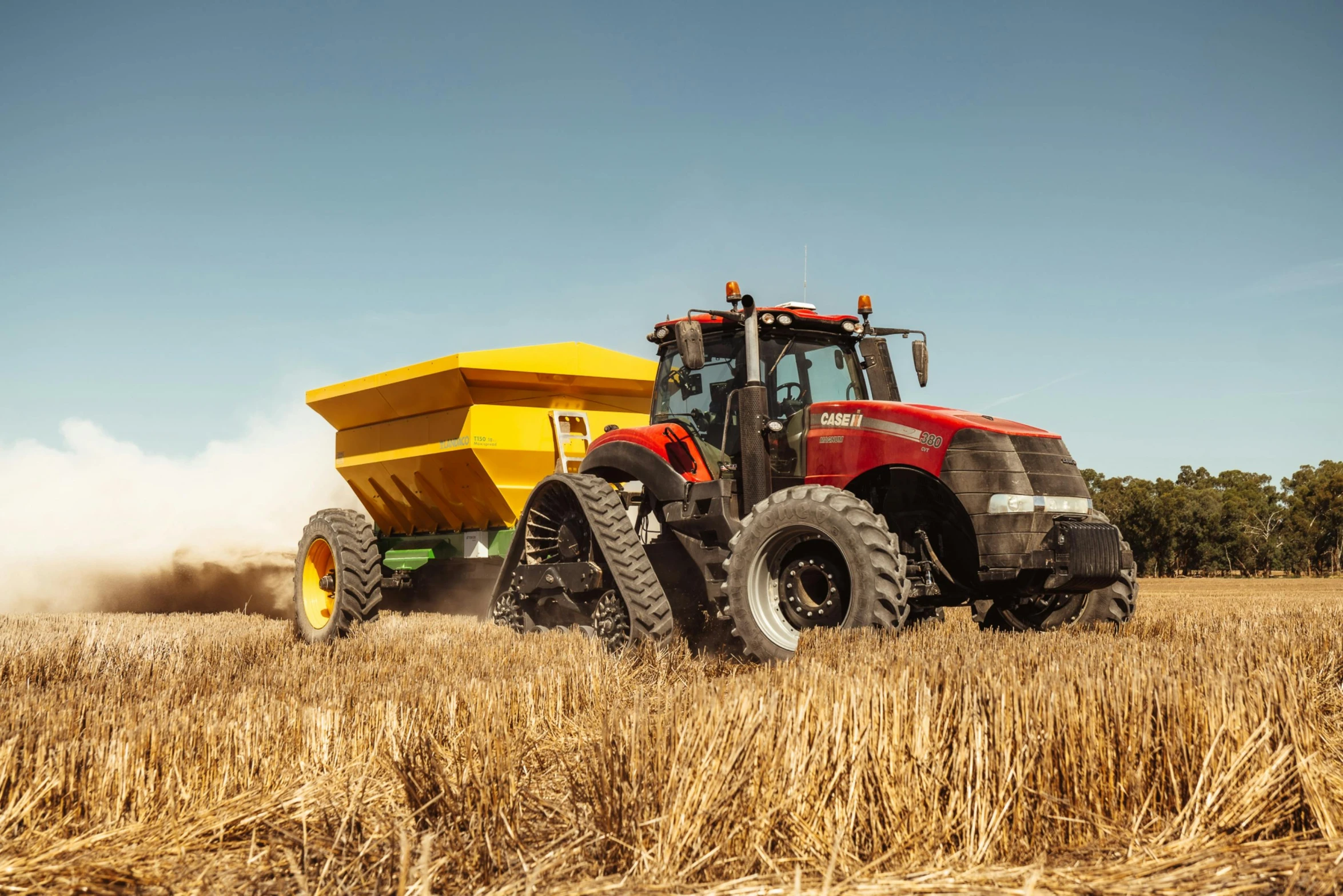 a large red and yellow truck in the middle of a wheat field