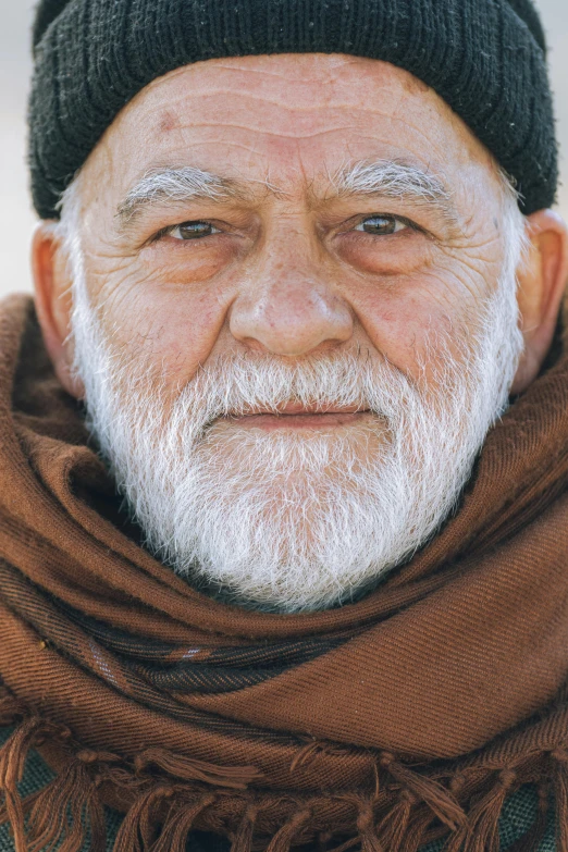 an old man with white hair and a beard wearing a hat