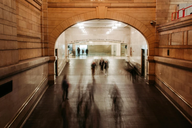 people moving through an industrial passage on a sunny day