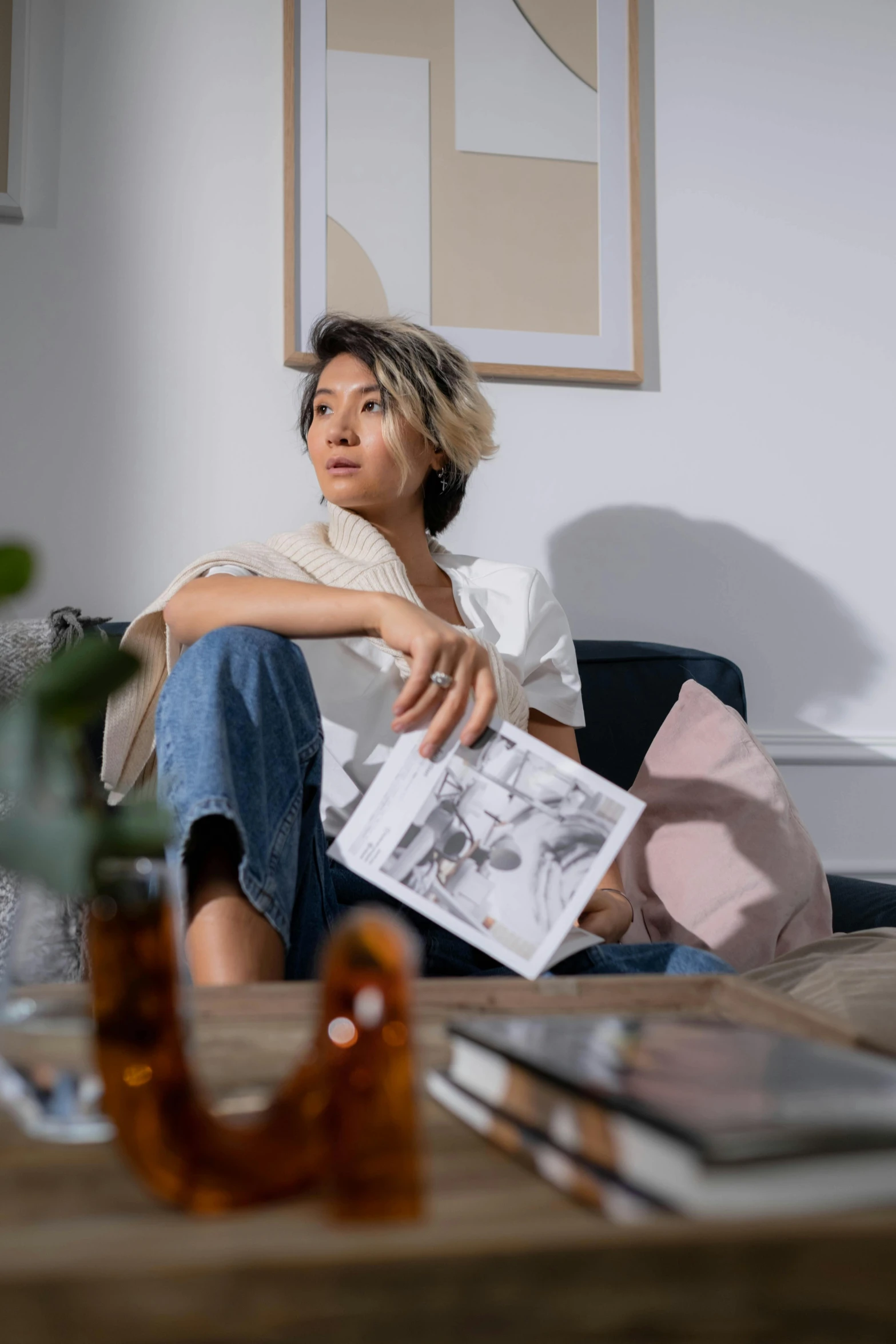 a woman sitting on a couch with books and laptops