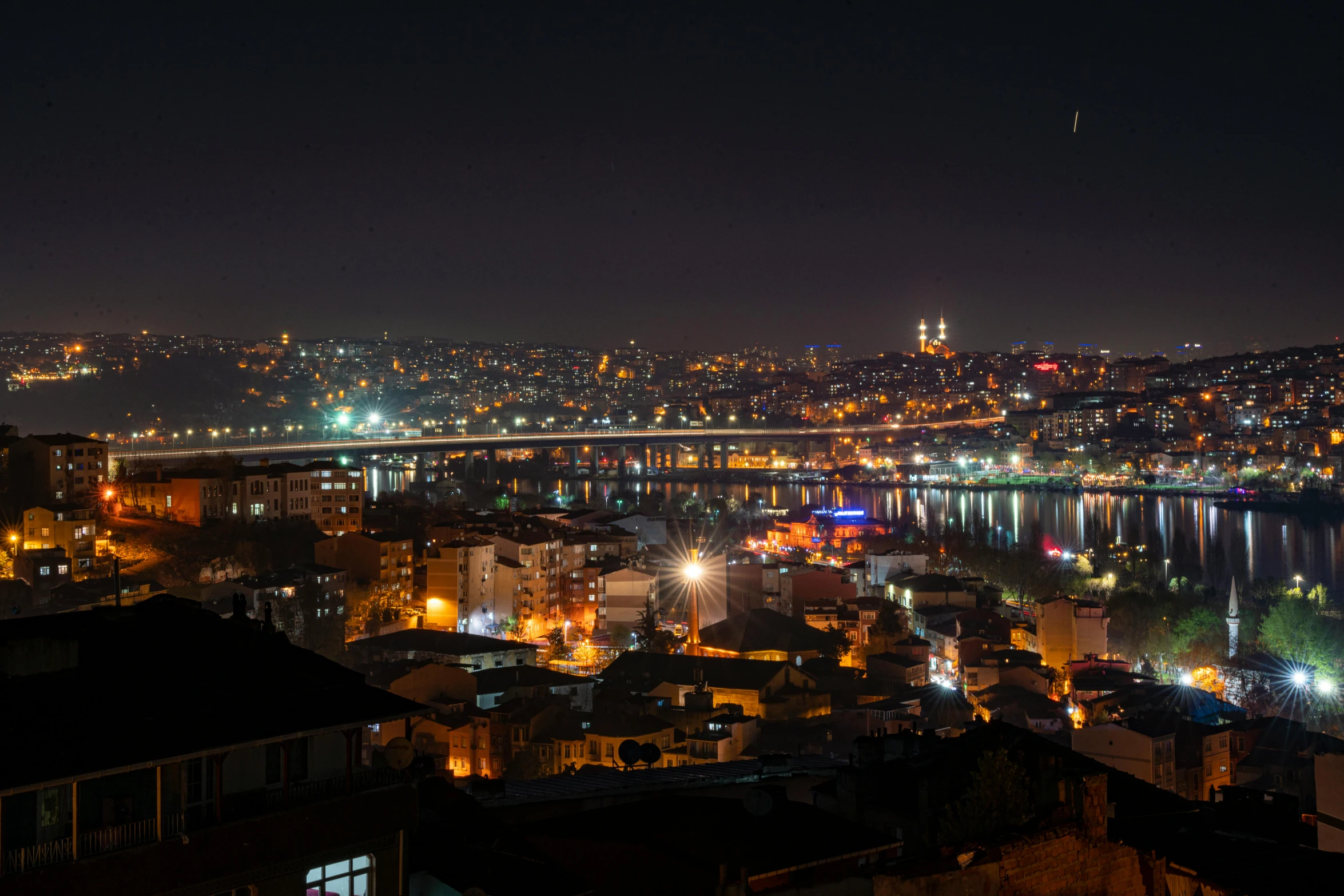 a city at night with lights around the skyline