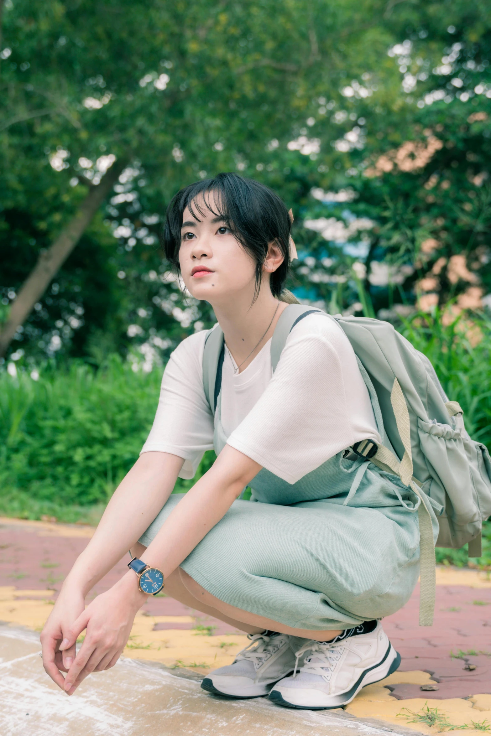 a woman kneeling down while holding a backpack