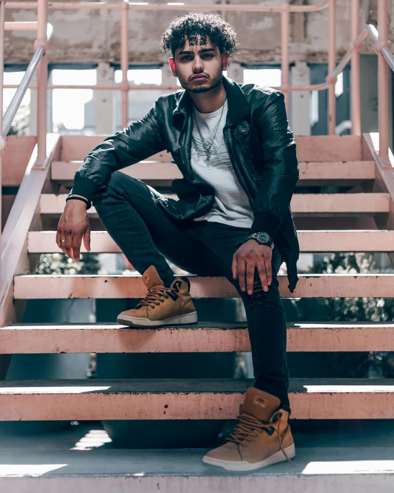 a man sitting on some stairs near the hand rail