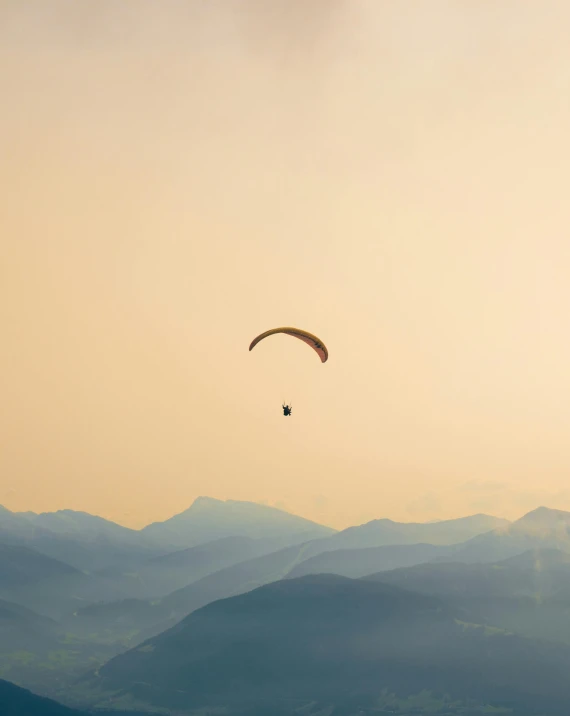 the kite is flying in the sky above the mountains