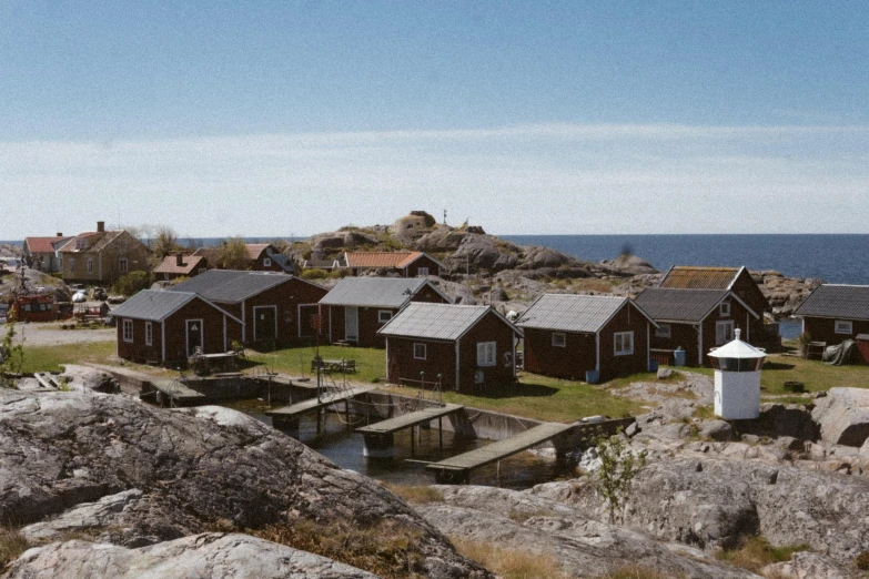 small wooden homes near the water and rocks
