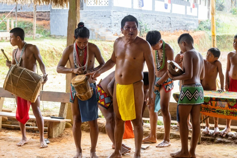 a group of people are standing and some with drums