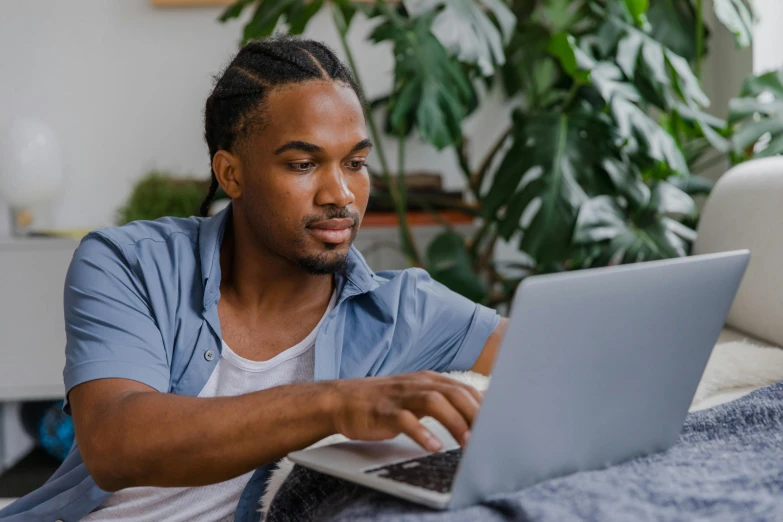 a man is looking at the computer on the couch