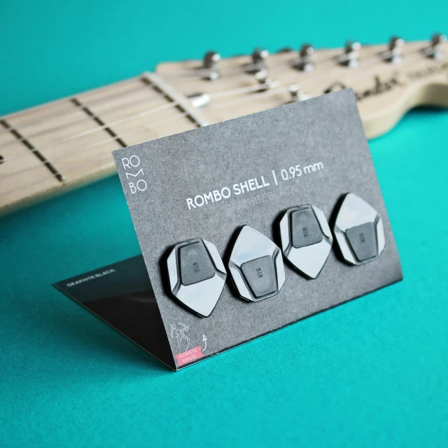 a notecard on top of a guitar, sitting next to the headstock