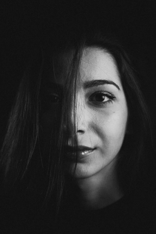 a woman with long hair looks into the camera