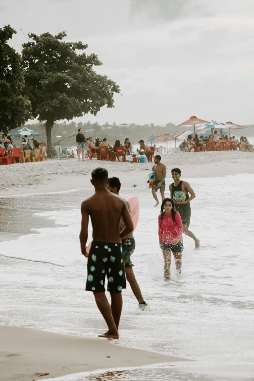 a group of people playing in the water at the beach