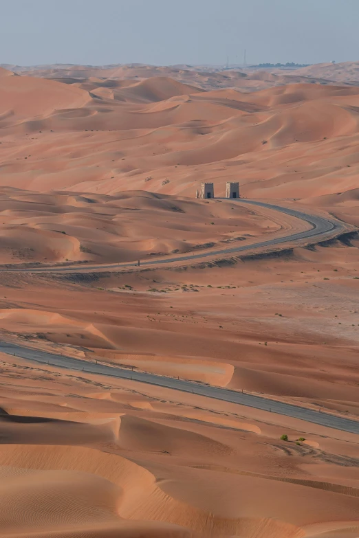 a desert scene with a road and car in the middle