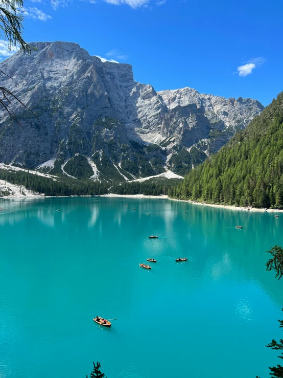 several boats floating on a beautiful turquoise lake