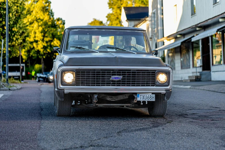 an old ford truck is parked in the middle of the street