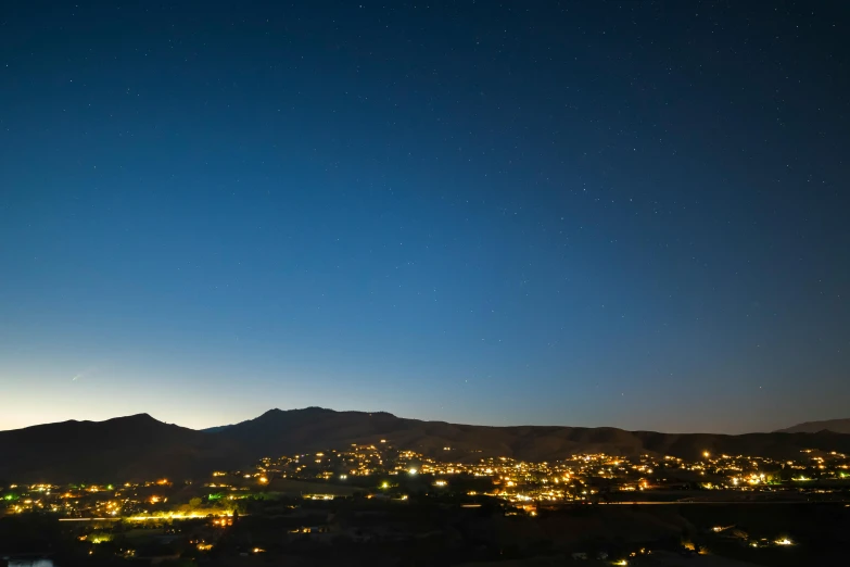 city lights shine bright at night near mountain