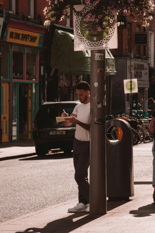 a man reading his paper at an outdoor street stand