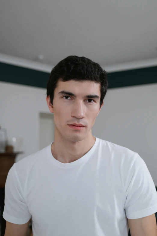 a man wearing white shirt standing in front of mirror