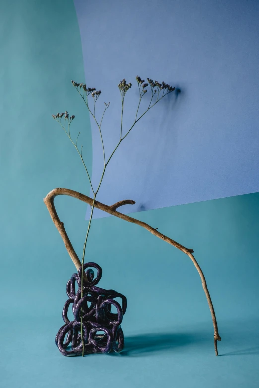 a sculpture made of sticks with flowers in it