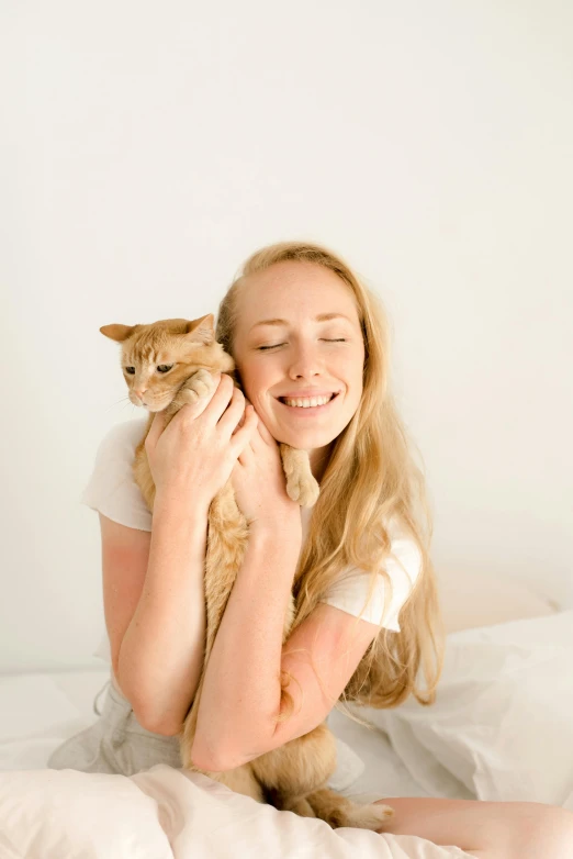 a woman is holding her cat in her arms and smiling