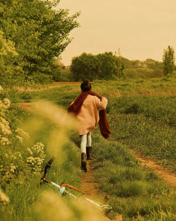 the woman walking is carrying a brown coat