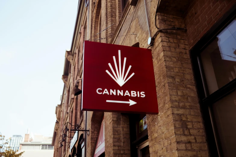 this is a red sign that says cannabis next to a building