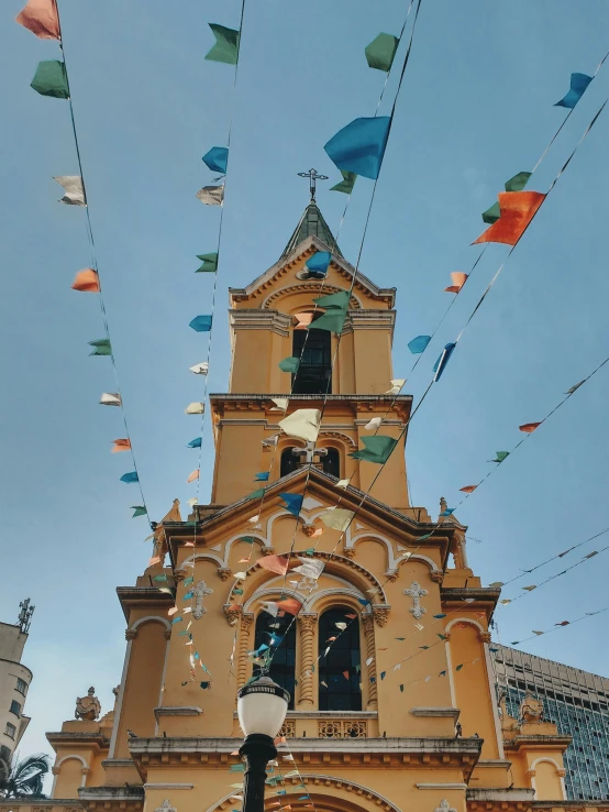 a cathedral with a sky background full of flags