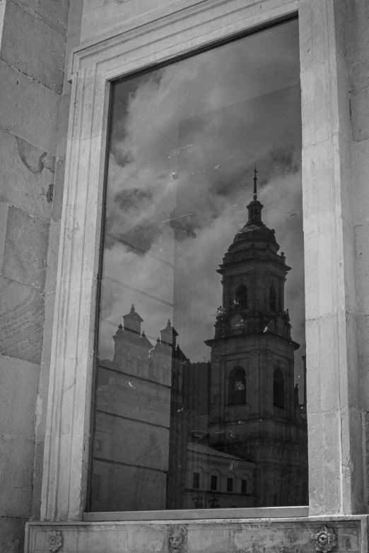 a window in a stone building, with reflection of clouds in the glass