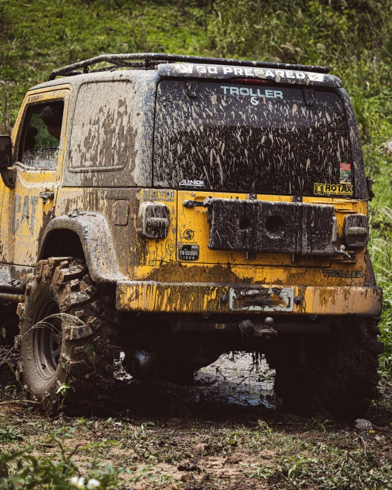 a yellow truck driving on a dirt road