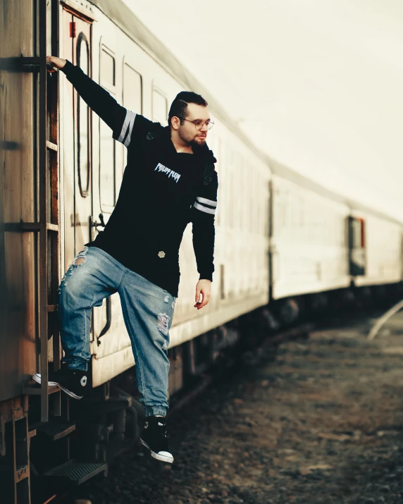 a man that is leaning on a train door