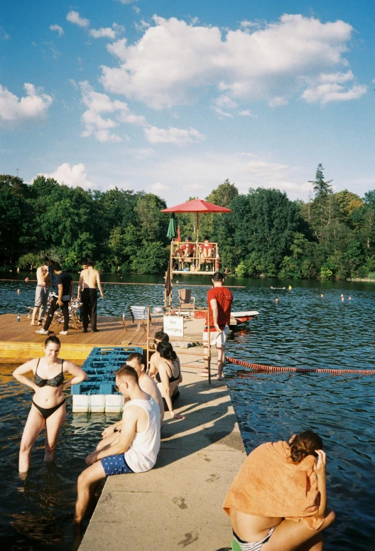 several people on a dock with a body of water