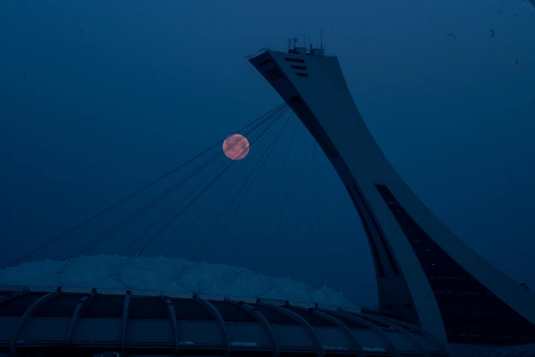 the moon in the sky over the top of an observation tower