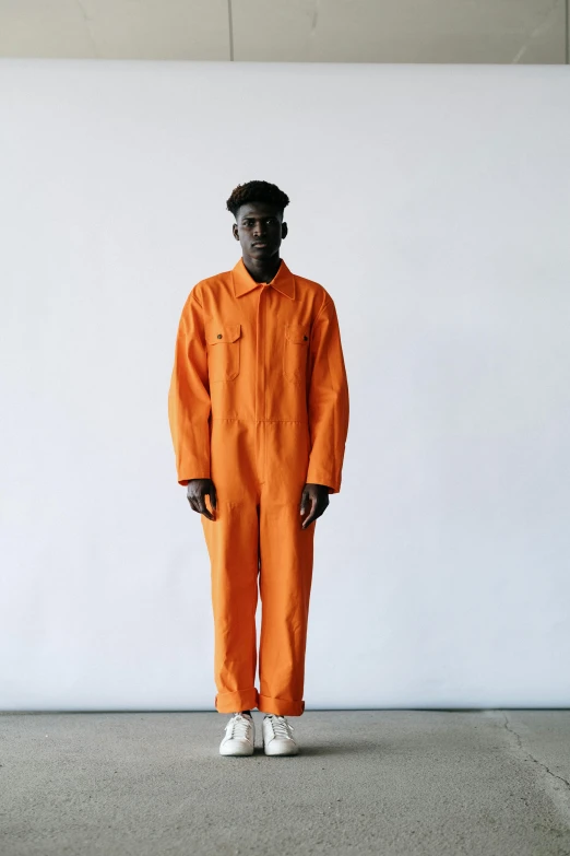 a man standing in an orange jumpsuit