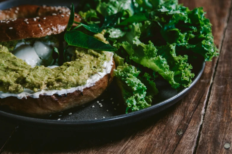 the bagel has been made with greens, sour cream, and a bit of sour cream