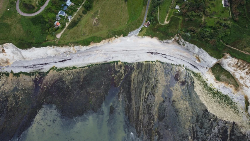 an aerial s shows cliffs along the edge of a beach and the surrounding water