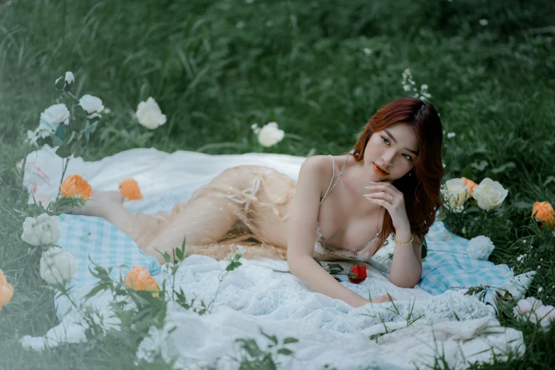 woman laying on the blanket with flowers behind her