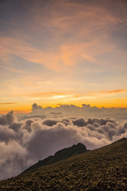 a view of clouds and mountains at dusk