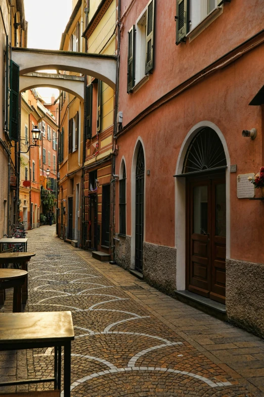 a narrow cobblestone street lined with old red buildings