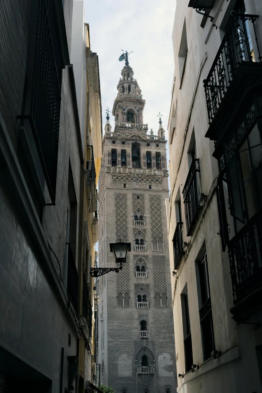 a clock tower rises over a narrow street