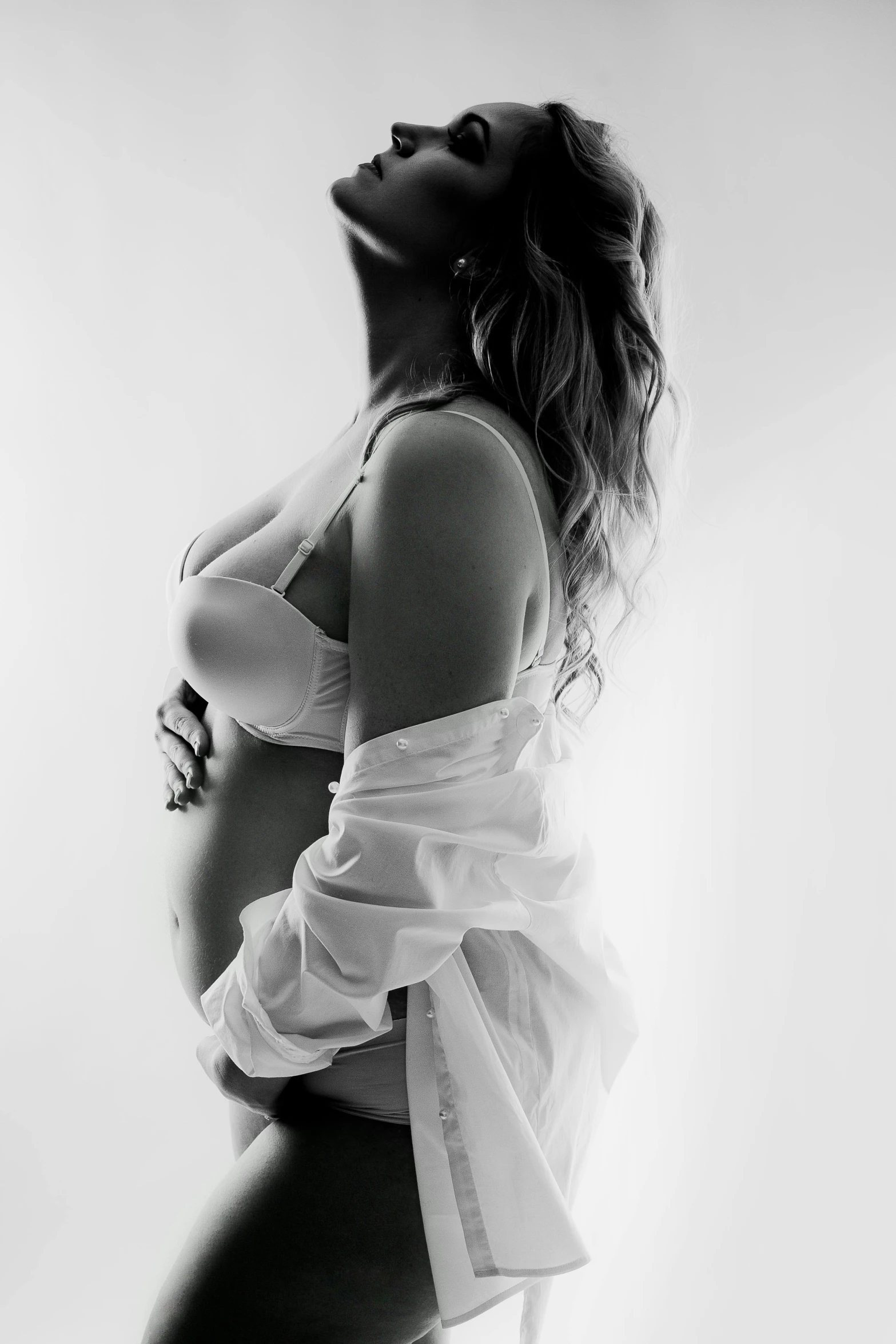 a pregnant woman poses with her hands on her stomach