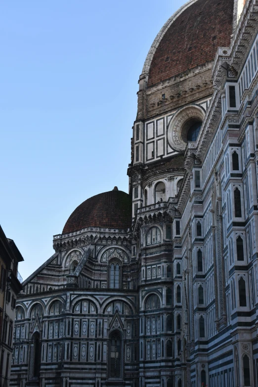 a large building sitting next to another building with arched windows