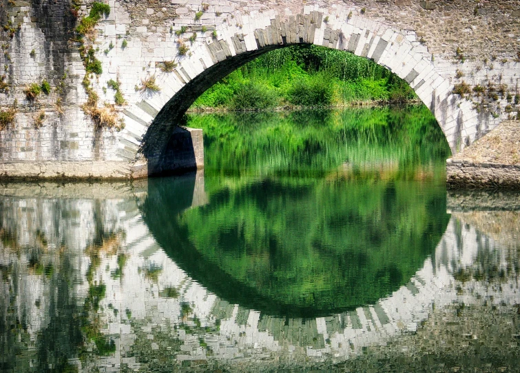 there is a stone bridge that has been built over water