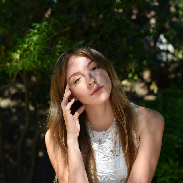 young woman with eyes closed and holding a cell phone to her ear