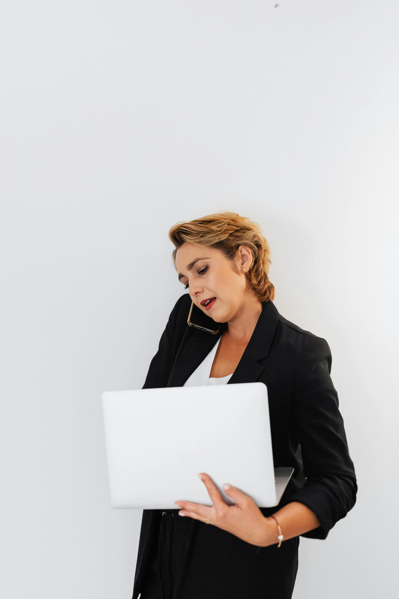 the woman in black is holding an apple laptop